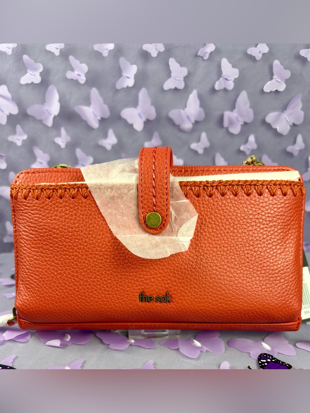 The Sak Orange Pebble Leather Cell Phone Wallet.